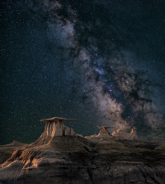 The Milky Way arching over a dark landscape